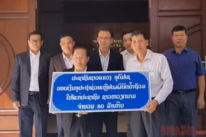 Đồng chí Somchit Panyasack (trái) trao 80 triệu kíp Lào ủng hộ nhân dân miền trung Việt Nam bị ảnh hưởng bởi bão lũ.