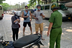 Lực lượng chức năng quận Ba Đình lập biên bản trường hợp đi ra đường khi không cần thiết.