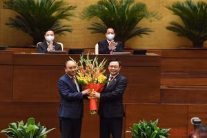 Chủ tịch Quốc hội Vương Đình Huệ tặng hoa chúc mừng Chủ tịch nước Nguyễn Xuân Phúc. (Ảnh: DUY LINH)