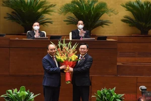 Chủ tịch Quốc hội Vương Đình Huệ tặng hoa chúc mừng Chủ tịch nước Nguyễn Xuân Phúc. (Ảnh: DUY LINH)