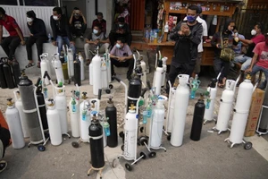 Người dân Jakarta, Indonesia xếp hàng chờ bơm đầy bình chứa oxy. (Ảnh: AP)