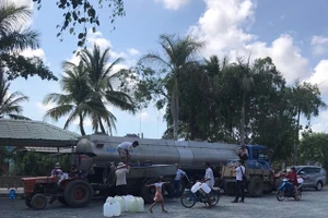 Người dân đến nhận nước miễn phí sáng 17-5.