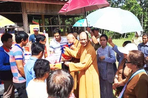 Thượng tọa Thích Minh Quang tặng quần áo, đồ dùng cho người dân Lào.