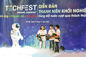 Màn đối thoại giữa rô-bốt và nhóm tác giả mũ cách ly di động Vihelm chống dịch Covid-19 tại lễ khai mạc diễn đàn Thanh niên khởi nghiệp năm 2020. Ảnh: ÐỨC ANH