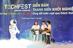 Màn đối thoại giữa rô-bốt và nhóm tác giả mũ cách ly di động Vihelm chống dịch Covid-19 tại lễ khai mạc diễn đàn Thanh niên khởi nghiệp năm 2020. Ảnh: ÐỨC ANH