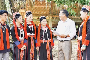 Tuyên truyền viên xã Chiêu Yên (huyện Yên Sơn, tỉnh Tuyên Quang) giải thích chính sách pháp luật cho bà con người dân tộc Dao thôn Tân Lập. Ảnh: TRANG TÂM