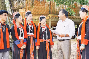 Tuyên truyền viên xã Chiêu Yên (huyện Yên Sơn, tỉnh Tuyên Quang) giải thích chính sách pháp luật cho bà con người dân tộc Dao thôn Tân Lập. Ảnh: TRANG TÂM