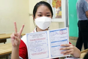 Trẻ được tiêm và nhận chứng nhận tiêm vắc-xin phòng Covid-19.