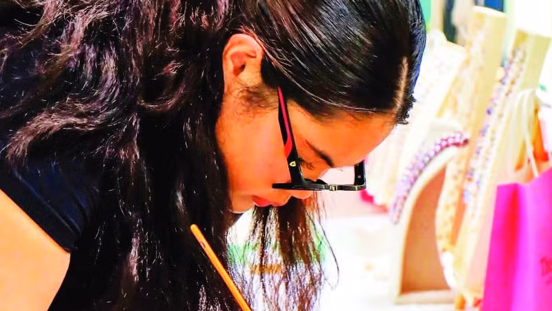 Mai Linh tỉ mỉ chỉnh lại những bức tranh trước khi triển lãm. (Ảnh CTV)