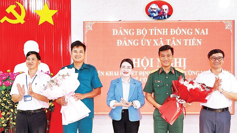 Lãnh đạo xã Tân Tiến (tỉnh Đồng Nai) tặng hoa chúc mừng các đồng chí sĩ quan về nhận nhiệm vụ tại Ban Chỉ huy quân sự xã.