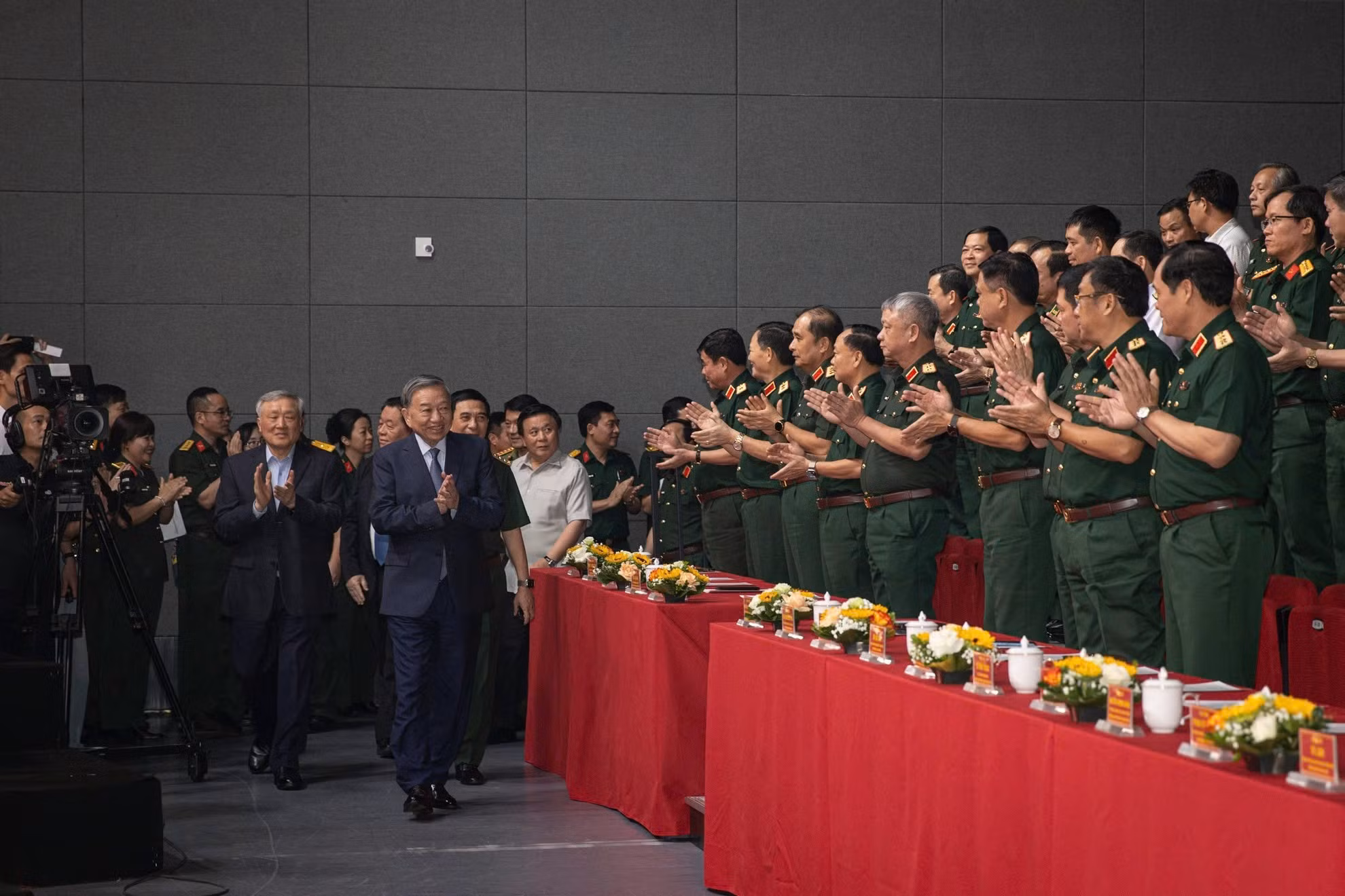Các đại biểu chào mừng Tổng Bí thư Tô Lâm cùng các đồng chí lãnh đạo Đảng, Nhà nước dự chương trình giao lưu nghệ thuật "Khắc ghi lời Bác - vang nhịp quân hành". (Ảnh: SƠN TÙNG)