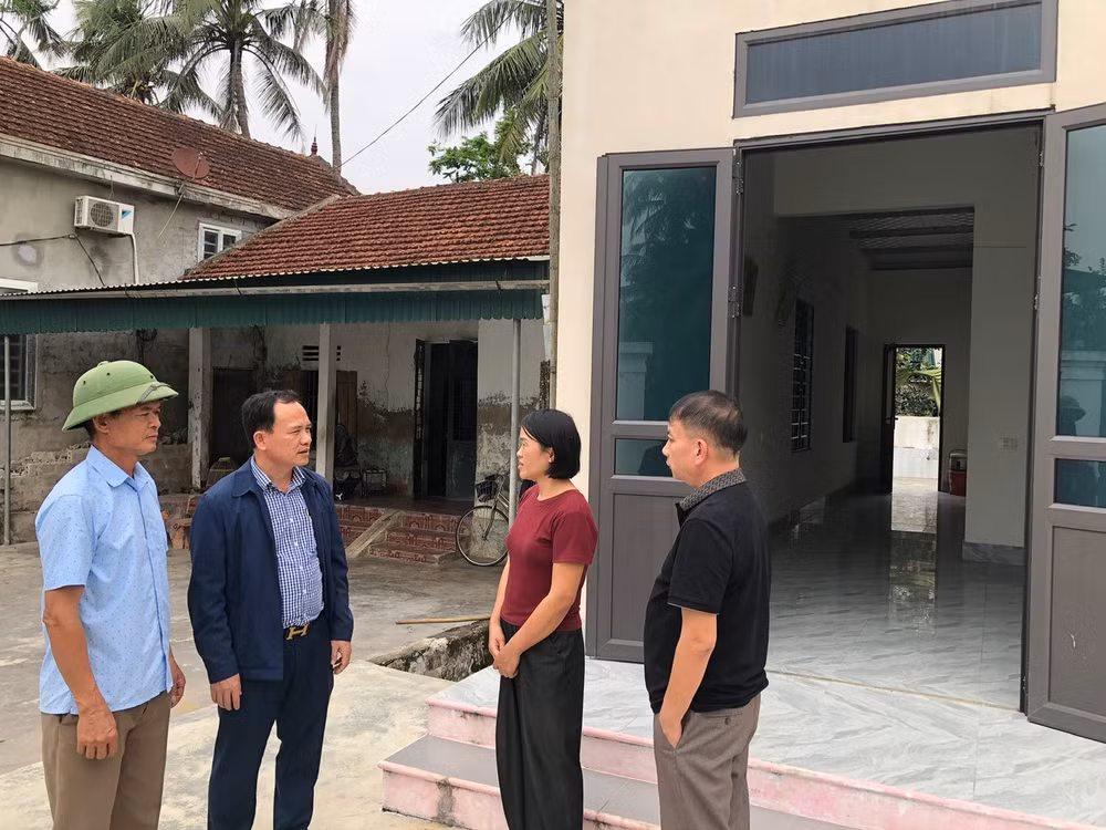 Cán bộ xã Đức Châu (Nghệ An) trao đổi với hộ nghèo được hỗ trợ xây nhà