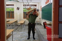 Lực lượng Công an tham gia vận chuyển bàn, ghế ở trường học lên chỗ cao.