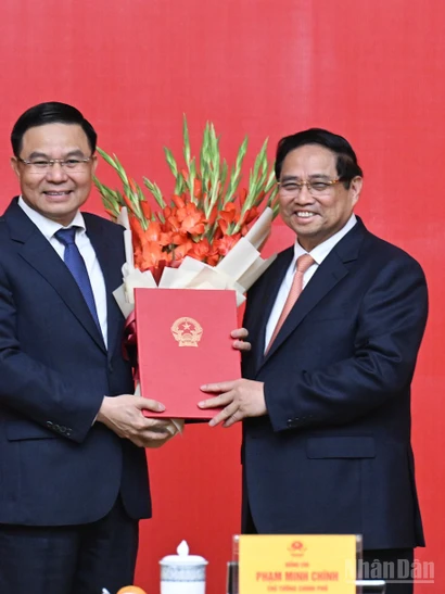 Thủ tướng Phạm Minh Chính trao Quyết định bổ nhiệm và tặng hoa chúc mừng đồng chí Lê Mạnh Hùng.