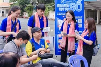 Sinh viên Học viện Cán bộ Thành phố Hồ Chí Minh trao đổi, hướng dẫn người dân đến giao dịch hành chính tại Ủy ban nhân dân phường Bình Thạnh.