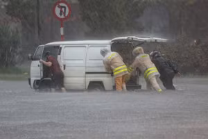 Đường phố ngập sâu, cảnh sát giao thông dầm mưa cùng người dân di chuyển phương tiện đến nơi an toàn.
