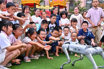 Trẻ em “giao lưu” với chó robot ở huyện Nhân Thọ, thành phố My Sơn, tỉnh Tứ Xuyên, Trung Quốc. (Ảnh: Tân Hoa Xã)