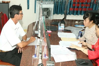 Cán bộ xã hướng dẫn thủ tục hành chính cho người dân.