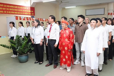 Nhà nghiên cứu Nguyễn Đình Tư (106 tuổi) mặc áo dài đỏ tham gia bầu cử sáng 15/3.