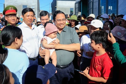 Thủ tướng Chính phủ Phạm Minh Chính ân cần thăm hỏi bà con nhân dân Khu tái định cư Quảng Đức, xã Tuy An Nam, tỉnh Đắk Lắk. (Ảnh: Nhật Bắc/VGP)