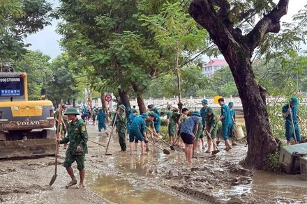 Bộ đội Biên phòng thành phố Huế cùng với lực lượng chính quyền địa phương dọn dẹp tại đường Phan Chu Trinh, phường Thuận Hóa. (Ảnh: VGP)