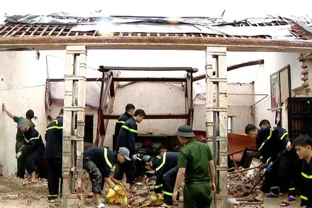 Các chiến sĩ Công an đang hỗ trợ người dân khắc phục hậu quả do bão số 10 gây ra. (Ảnh: VGP)