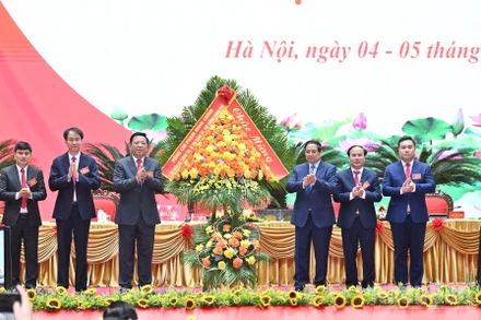 Bí thư Đảng ủy Chính phủ, Thủ tướng Chính phủ Phạm Minh Chính tặng hoa chúc mừng Đại hội đại biểu Đảng bộ Bộ Xây dựng lần thứ I, nhiệm kỳ 2025-2030. (Ảnh: TRẦN HẢI)