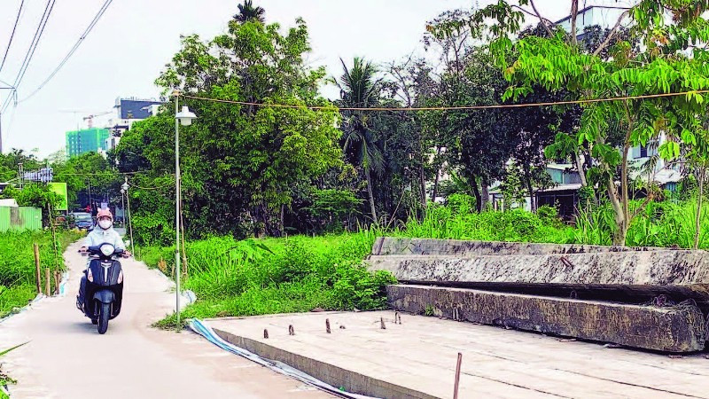 Cầu Trần Bạch Đằng ngừng thi công, người dân phải tự làm đường dân sinh đi lại giữa hai khu tái định cư.