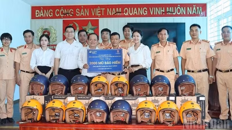Đại diện Tập đoàn Quốc tế Á Châu phối hợp Phòng Cảnh sát giao thông Công an tỉnh Quảng Ngãi trao tặng 2.000 mũ bảo hiểm đạt chuẩn cho người dân. 