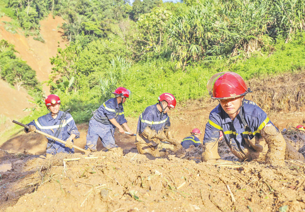 Các chiến sĩ Phòng cháy, chữa cháy và Cứu nạn, cứu hộ tìm kiếm các nạn nhân. (Ảnh: TTXVN) mua-lu.png