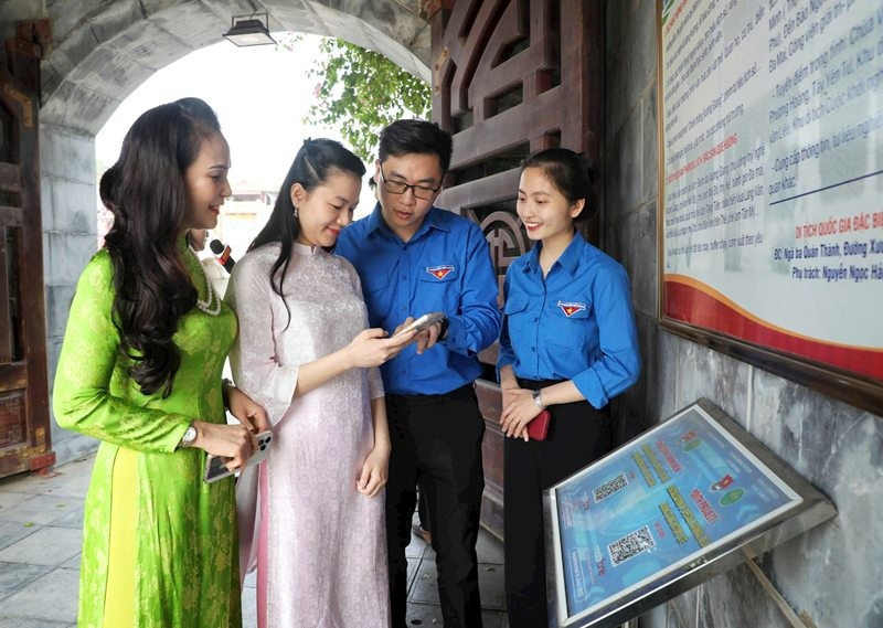 Đoàn viên, thanh niên tỉnh Bắc Giang hướng dẫn người dân quét mã QR khi đến tham quan Khu di tích chiến thắng Xương Giang. (Ảnh: DANH LAM)