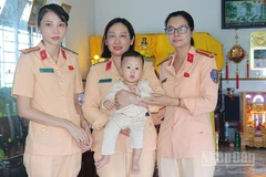 Cháu Lê Tiên bên vòng tay yêu thương của cán bộ, chiến sĩ cảnh sát giao thông.