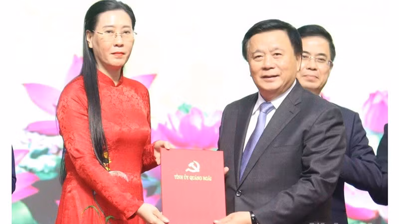 Đồng chí Nguyễn Xuân Thắng, Ủy viên Bộ Chính trị, Giám đốc Học viện Chính trị Quốc gia Hồ Chí Minh, Chủ tịch Hội đồng Lý luận Trung ương trao Quyết định của Bộ Chính trị về việc thành lập Đảng bộ tỉnh Quảng Ngãi cho Bí thư Tỉnh ủy Quảng Ngãi Bùi Thị Quỳnh Vân. 