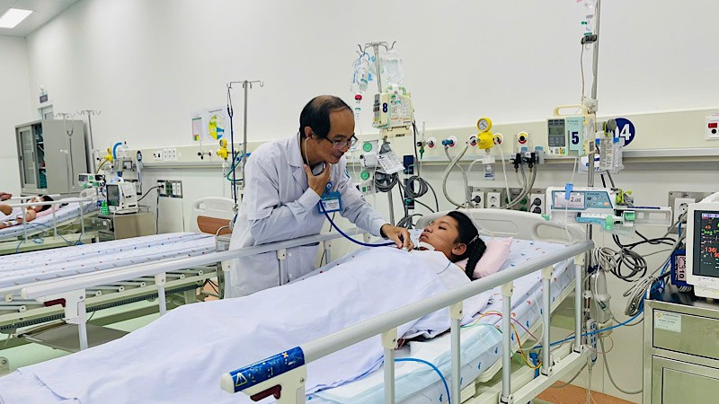 Phó Giáo sư, Tiến sĩ, bác sĩ Phạm Văn Quang, Trưởng khoa Hồi sức tích cực-Chống độc, Bệnh viện Nhi đồng 1 khám bệnh nhi nữ 12 tuổi từ Trà Vinh. (Ảnh: CHI MAI)