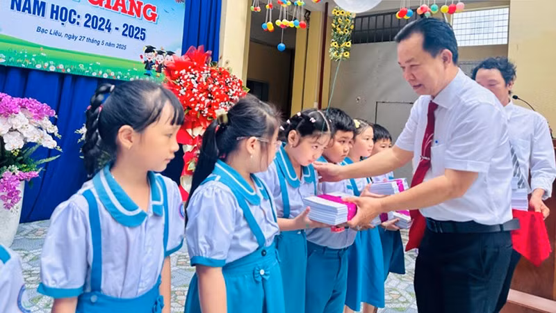 Thầy Trần Văn Sơn, Hiệu trưởng Trường Tiểu học Kim Đồng (thành phố Bạc Liêu) trao phần thưởng các em học sinh xuất sắc, năm học 2024-2025. (Ảnh: TRỌNG DUY)