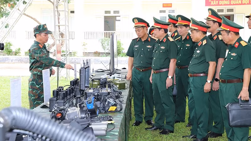 Đoàn công tác tham quan khu vực trưng bày trang thiết bị kỹ thuật.