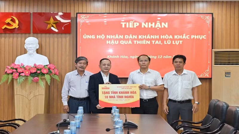 Đồng chí Nguyễn Khắc Hà (thứ hai từ phải sang) tiếp nhận hỗ trợ từ Báo Nhân Dân. (Ảnh: VĨNH THÀNH) 