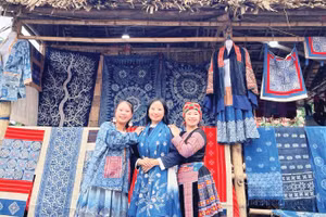 Hàng Y Cô (ngoài cùng bên trái) tại gian hàng thổ cẩm H'Mông của mình.