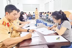 Người dân thực hiện thủ tục thi sát hạch lái xe ô-tô. (Ảnh: QUANG QUÝ)