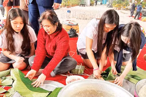 Các em học sinh trải nghiệm gói bánh chưng cùng hội viên Câu lạc bộ Liên thế hệ tự giúp nhau phường Khương Đình (thành phố Hà Nội).