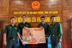 Các chiến sĩ đồn biên phòng cửa khẩu cảng An Thới vui mừng đón nhận phụ san đặc biệt của báo Nhân Dân.