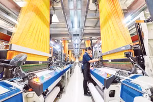 Công nhân vận hành dây chuyền dệt hiện đại tại Công ty Thái Tuấn (Thành phố Hồ Chí Minh).