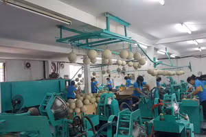 Người lao động với dây chuyền sản xuất bóng thi đấu tại Công ty cổ phần Động Lực. (Ảnh: HOÀI THU)