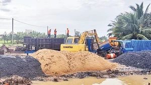 Lực lượng thi công Dự án Đường tỉnh 927 tranh thủ trở lại công trường sau cơn mưa.