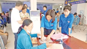 Đoàn viên, thanh niên xã Ô Diên hướng dẫn người dân rà soát lại hồ sơ trước khi nộp thủ tục hành chính.
