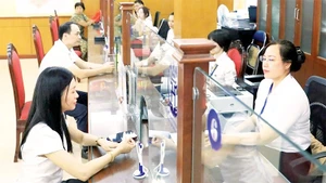 Giải quyết thủ tục hành chính cho người dân tại điểm phục vụ hành chính công phường Thanh Xuân. (Ảnh QUANG THÁI)