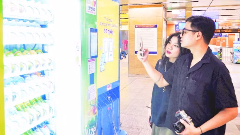 Hành khách mua đồ uống tại máy bán hàng tự động ở nhà ga ngầm của tuyến Metro Bến Thành-Suối Tiên. (Ảnh THẾ ANH)