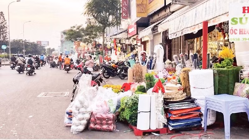 Các hộ kinh doanh trên đường Hải Thượng Lãn Ông bày hàng hóa lấn chiếm đường giao thông. (Ảnh HƯƠNG MỸ)