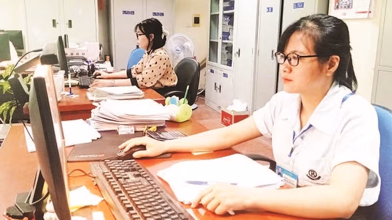 Cán bộ Đội Thuế thành phố Bắc Giang rà soát hồ sơ để thực hiện giảm tiền thuê đất cho doanh nghiệp. (Ảnh MINH LINH)