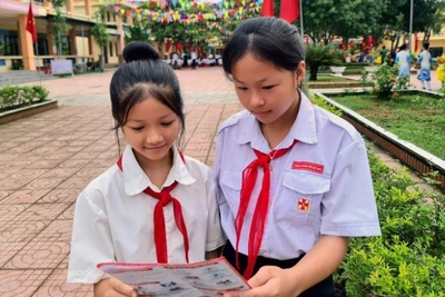 Các em học sinh tìm hiểu về quyền lợi khi tham gia bảo hiểm y tế. (Ảnh: TÂM TRUNG)